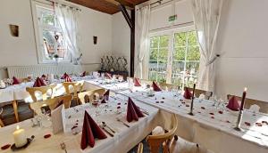 a large room with tables with red napkins and candles at Wegeners Landhaus UG in Uelzen