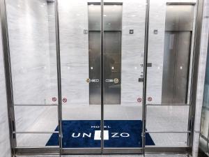 two elevator doors in a building with the words uniao at HOTEL UNIZO Yokohamaeki-West in Yokohama
