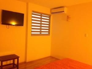 a yellow room with a window and a television at Hotel CR Tehuacan in Tehuacán