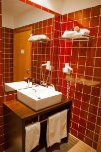 a bathroom with a white sink and a mirror at Hotel Vila Luena in Vila Verde