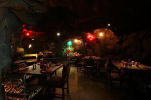 a restaurant with tables and chairs in a cave at Hotel Pai Vista in Mysore