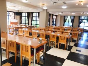 a classroom with tables and chairs in a room with windows at Kagoshima Daiichi Hotel Kishaba in Kagoshima