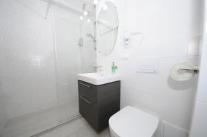 un bagno con un water, un lavandino e uno specchio di Apartament Panoramic a Galaţi Altre 17 foto