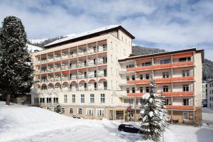 ein großes Gebäude mit Schnee davor in der Unterkunft Hotel National by Mountain Hotels in Davos