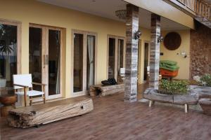 a porch of a house with a bench and windows at AgaLiving Medewi in Pulukan