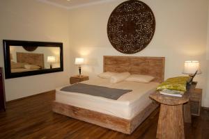 a bedroom with a bed and a large mirror at AgaLiving Medewi in Pulukan