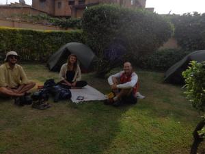 eine Gruppe von Menschen, die mit Sonnenschirmen im Gras sitzen in der Unterkunft Kabale Back Packers in Kabale