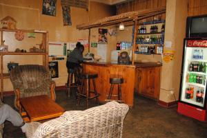 un hombre sentado en un bar en un restaurante en Kabale Back Packers, en Kabale