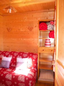 a small room with a red couch in a cabin at MONT BLANC SOLEIL E-2 in Manigod
