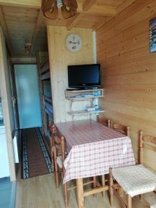 une salle à manger avec une table et une télévision dans l'établissement MONT BLANC SOLEIL E-2, à Manigod