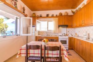 uma cozinha com uma mesa com cadeiras e uma janela em Casa Soula, Gaios Seaview Cottage em Gaios