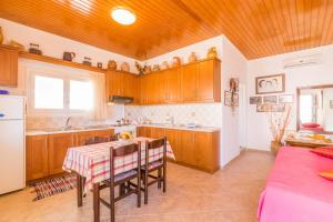 uma cozinha com armários de madeira e uma mesa com cadeiras em Casa Soula, Gaios Seaview Cottage em Gaios