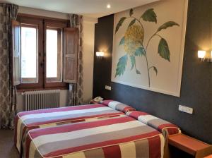 a bedroom with two beds and a painting on the wall at Hotel Monasterio de Leyre in Yesa
