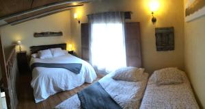 a bedroom with two beds and a window at El Jardín Secreto in Orés +46 photos