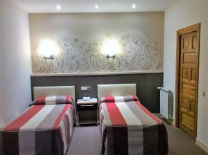 una camera d'albergo con 2 letti e una scrivania di Hotel Monasterio de Leyre a Yesa