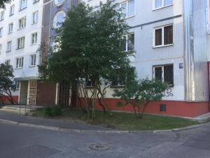 un bâtiment blanc avec un arbre devant lui dans l'établissement Kvartira v Rige, à Riga