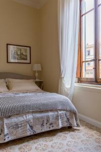 een slaapkamer met een bed en een raam bij Perle d'Ambra in Lucca