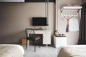 ein Schlafzimmer mit einem Schreibtisch mit einem Fernseher und einem Bett in der Unterkunft Ob-Oon Boutique Bed & Breakfast in Bangkok