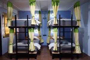 ein Schlafzimmer mit Etagenbetten in einem Zimmer mit blauen Wänden in der Unterkunft Tangmo House in Chiang Mai