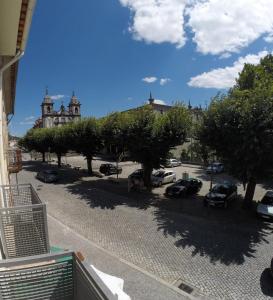 eine Straße mit Autos auf einem Parkplatz mit Bäumen in der Unterkunft BOURO (Santa Maria) Appartement in Bouro