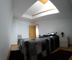 Schlafzimmer mit einem großen Bett und einem großen Dachfenster in der Unterkunft BOURO (Santa Maria) Appartement in Bouro