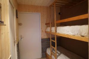 a room with two bunk beds and a door at La Godille in Pra-Loup