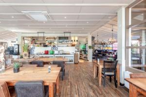 a restaurant with wooden tables and chairs at Hajé Restaurant de Aalscholver in Lelystad