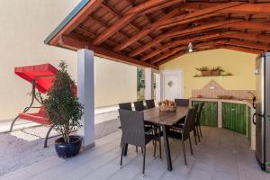 a patio with a wooden table and chairs at Villa Monique in Vodnjan