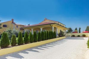 a large yellow house with a driveway at Villa Monique in Vodnjan