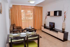 een woonkamer met een eettafel en een televisie bij OLYMP Apart-Complex in Sveti Vlas