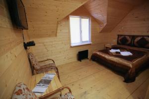 - une chambre avec un lit et un canapé dans une cabine dans l'établissement Sadyba Lisova Kvitka, à Verkhniy Yasenov