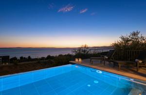 a swimming pool with a view of the ocean at A brand NEW VILLA - Infinity in Podstrana