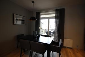 ein Esszimmer mit einem Tisch, Stühlen und einem Fenster in der Unterkunft KRSferie leiligheter i sentrum in Kristiansand