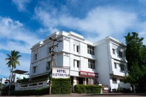 坦贾武尔Hotel Victoriyah的前面有标志的白色建筑