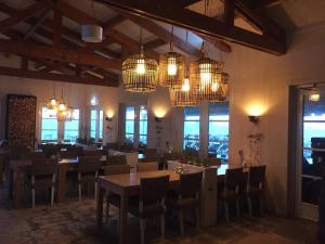 スカーレンデイケにあるFerienhaus Nordseeliebeのテーブルと椅子とシャンデリアのあるダイニングルーム