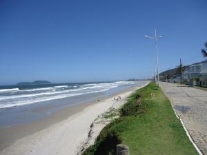 una playa con gente caminando por la arena y el océano en Apartamento Favreto, en Marechal Luz