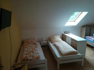 two beds in a room with a window at Haus am See in Unterwellenborn