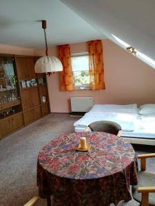 een woonkamer met een tafel en een bed bij Haus am See in Unterwellenborn