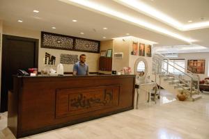 アンマンにあるMadina Suitesの店のカウンターに立っている男性