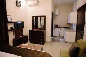 a living room with a couch and a tv and a kitchen at Madina Suites in Amman