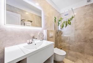 a bathroom with a sink and a toilet and a mirror at A brand NEW VILLA - Infinity in Podstrana