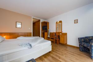 um quarto de hotel com uma cama e uma cadeira em Hotel Móló em Siófok