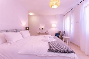 a white bedroom with a large white bed and a table at Livemálaga Terrace Deluxe in Málaga