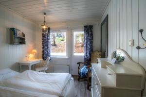 a bedroom with a bed and a desk and a window at Tønsberg Vandrerhjem in Tønsberg