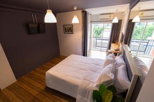 a bedroom with a large bed with white sheets at Mango 10 House in Bangkok