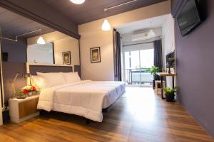 a bedroom with a large bed and a large window at Mango 10 House in Bangkok