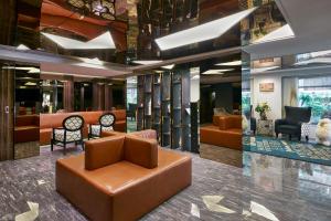 a lobby with couches and chairs in a building at Sora Hotel Silom in Bangkok +27 photos