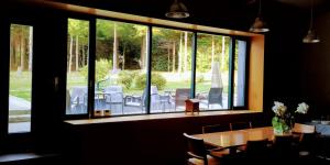 a dining room with a table and a large window at Casa Garea in Arzúa