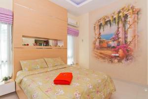 ein Schlafzimmer mit einem Bett mit einem roten Hut darauf in der Unterkunft Villa Nataly in Na Jomtien