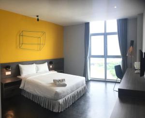 um quarto de hotel com uma cama com um urso de peluche em KIP Hotel em Kuala Lumpur